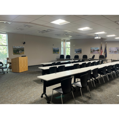 Room with tables, chairs and podium.