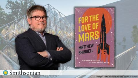 the author, a man with glasses, stands next to his book titled "For the Love of Mars"