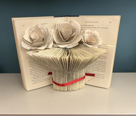 a photo of  a book made to look like a vase with flowers made out of book pages